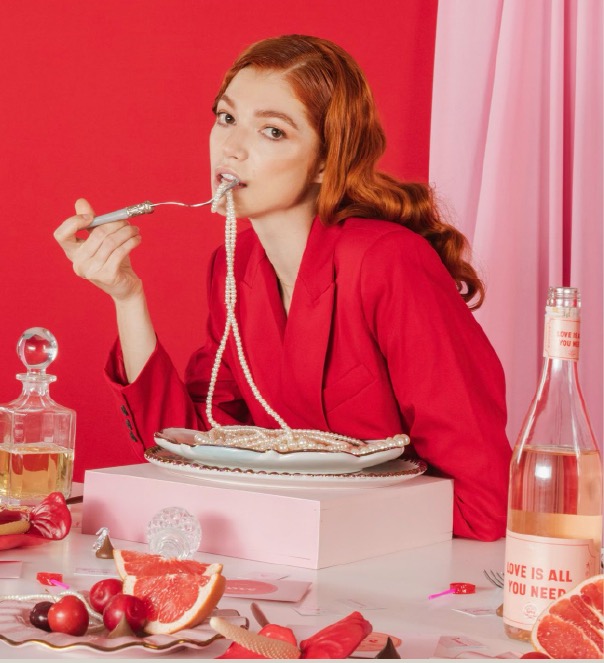 Lifestyle photography — woman in red eating pearls